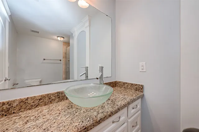 a bathroom with a granite countertop sink and a mirror