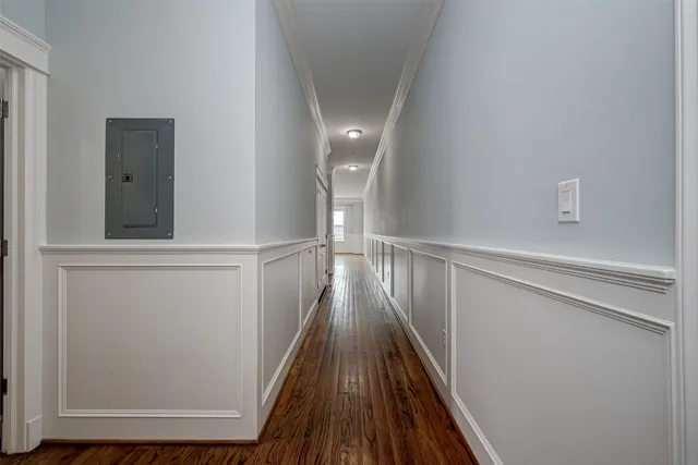 a view of a hallway with wooden floor and staircase