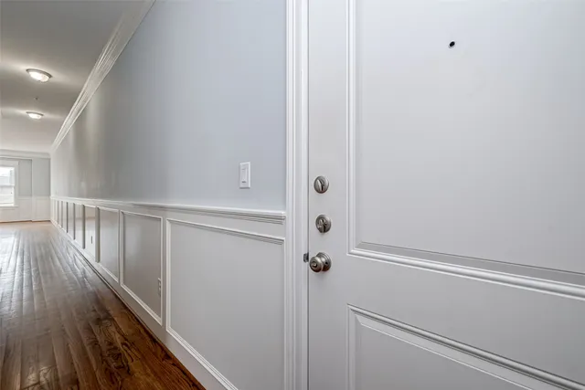 a view of a hallway with wooden floor and entryway