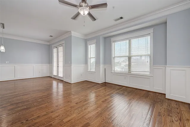 a view of an empty room with wooden floor and window