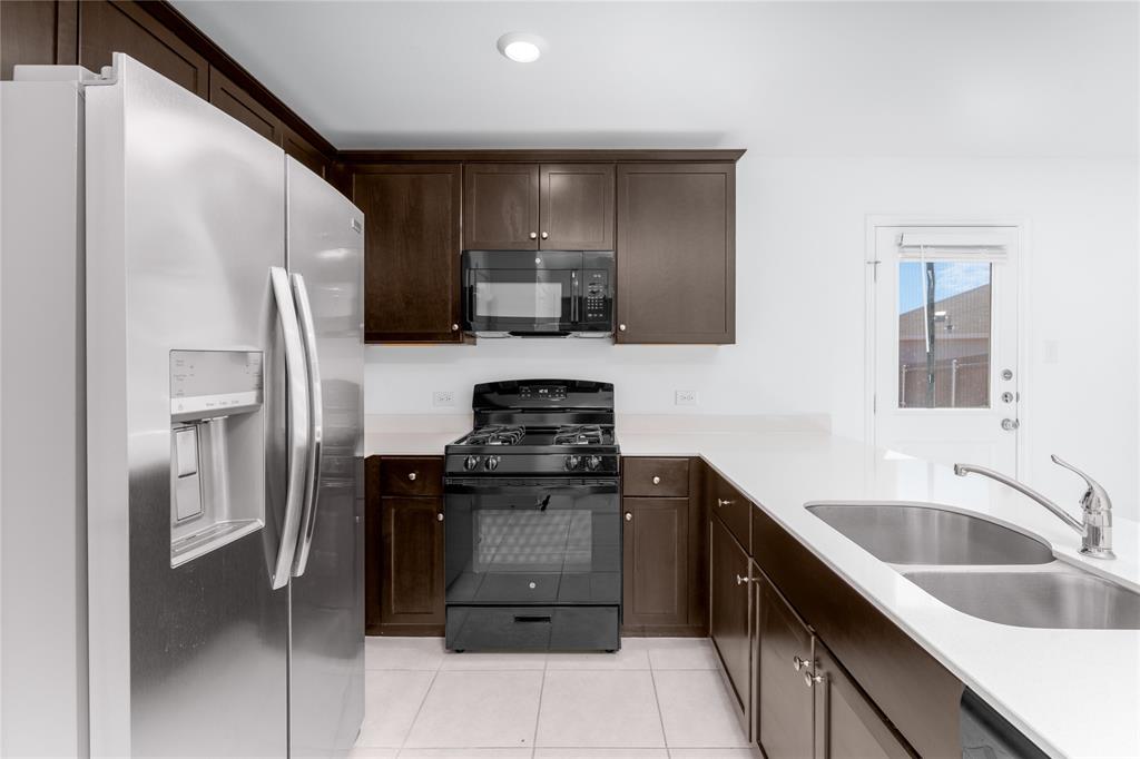 7524 Larson Lane McKinney, TX 75071 - Photo 11 of 24 a kitchen with a sink stove and refrigerator