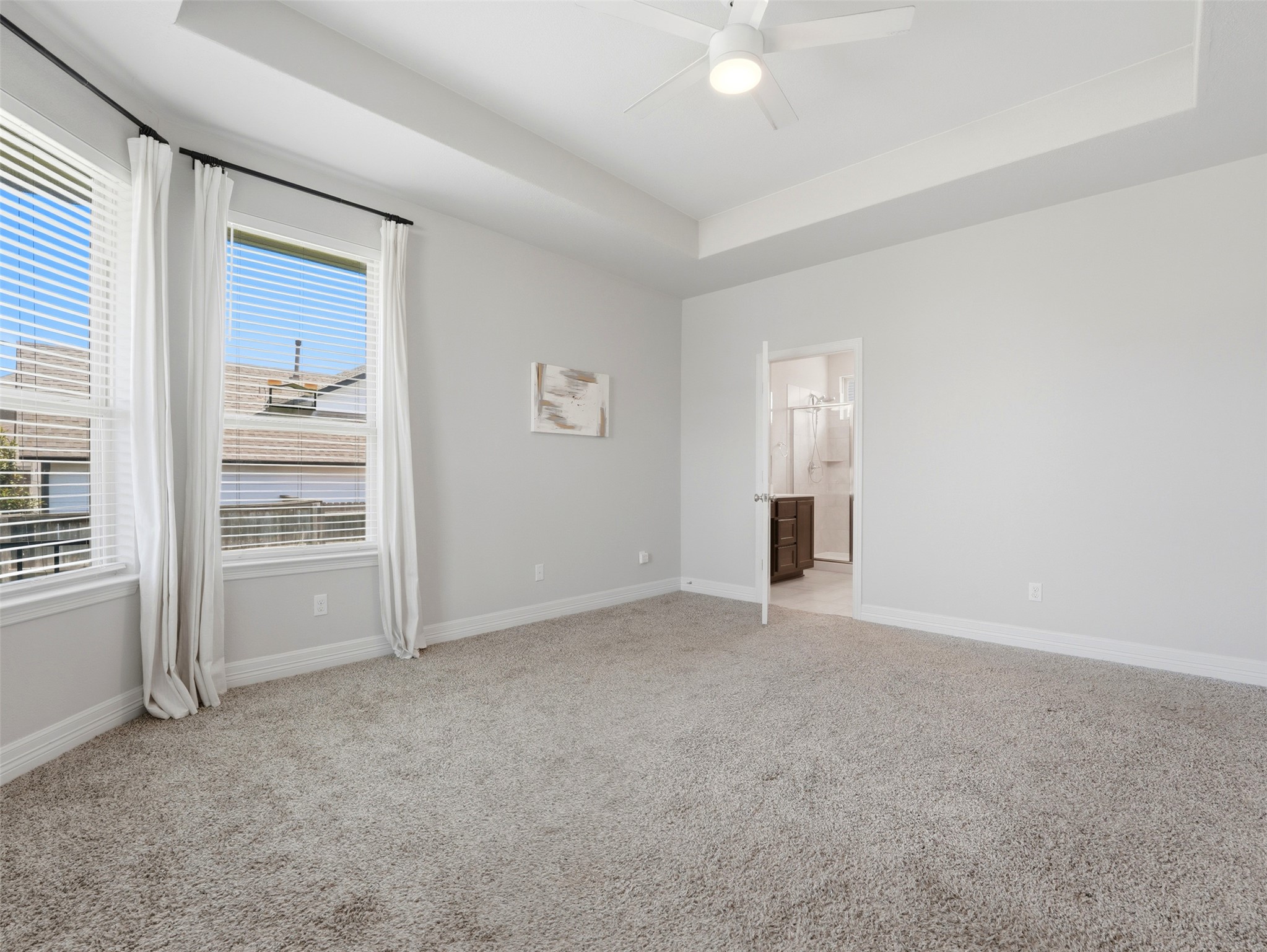 2132 Ringstaff Road Leander, TX 78641 - Photo 32 of 39 A spacious primary bedroom features soft carpeting, a ceiling fan, and ample window light.