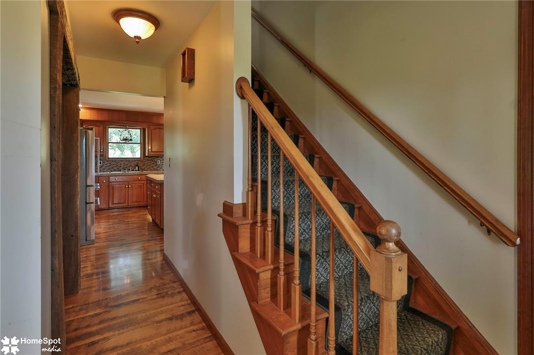 829 Georgetown Road Nazareth, PA 18064 - Photo 10 of 54 Rich laminate floors line the entryway leading to a classic staircase and kitchen beyond.