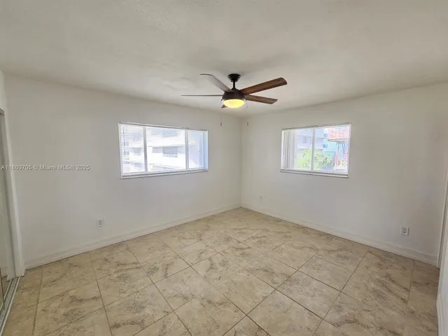 a view of an empty room with a ceiling fan