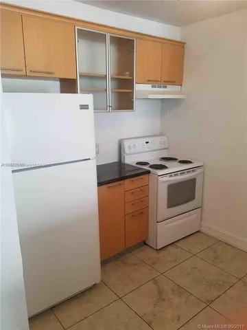 a kitchen with a refrigerator and a stove