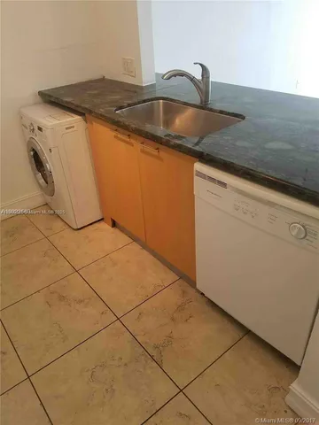 a kitchen with granite countertop a sink and a stove