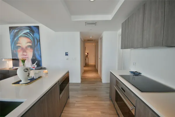 a hallway with a sink and cabinets