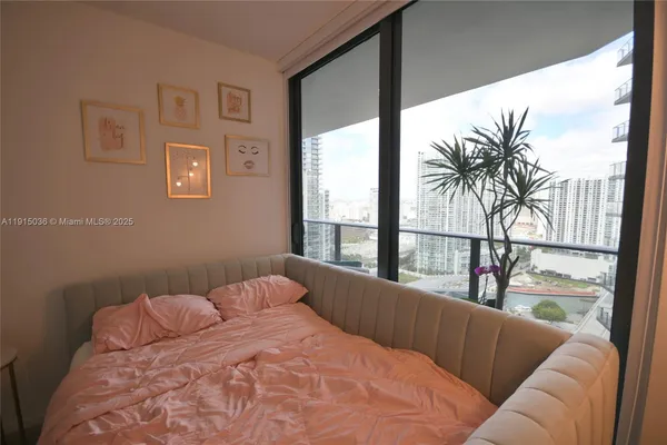 a bedroom with a large window and a balcony