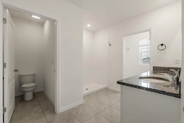 a bathroom with a granite countertop sink a toilet and a mirror