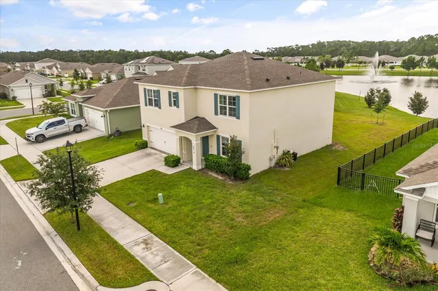 a view of a house with a yard and lake view