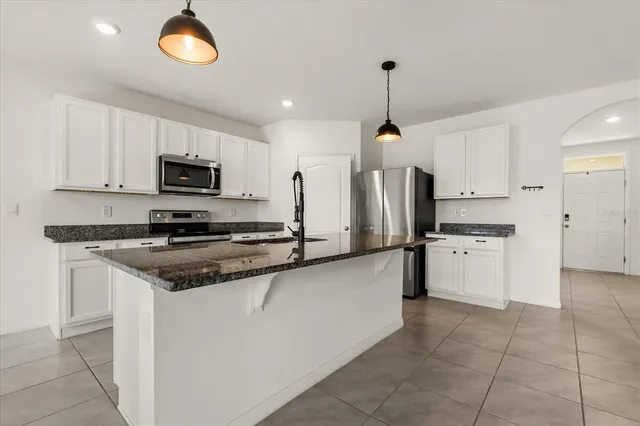 a kitchen with stainless steel appliances a refrigerator sink and microwave