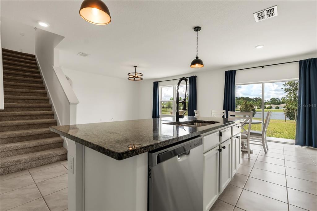 6814 Grace Hammock Road Harmony, FL 34773 - Photo 6 of 41 a kitchen with stainless steel appliances granite countertop a sink and a refrigerator