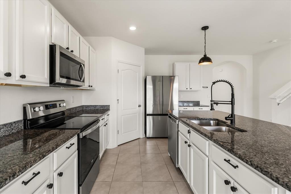 6814 Grace Hammock Road Harmony, FL 34773 - Photo 7 of 41 a kitchen with granite countertop stainless steel appliances and sink