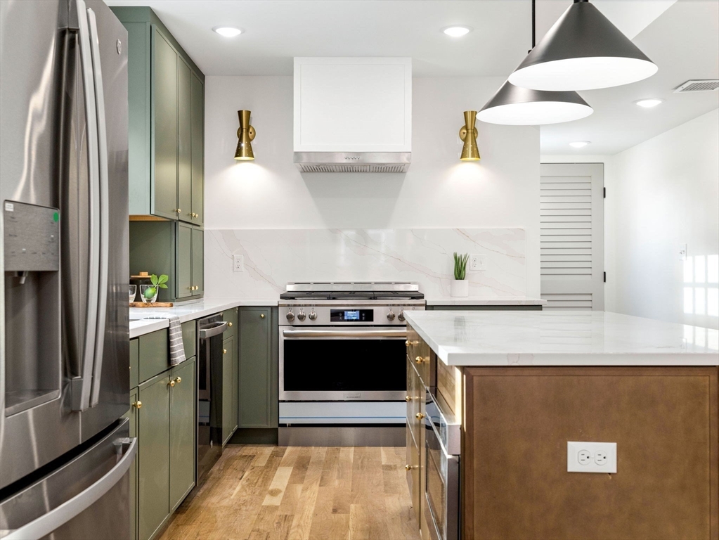 a kitchen with stainless steel appliances granite countertop a stove a sink and a refrigerator