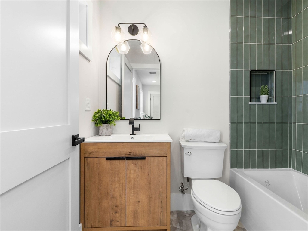 16 High Street, Unit 2 Somerville, MA 02144 - Photo 11 of 34 a bathroom with a granite countertop sink a toilet and shower