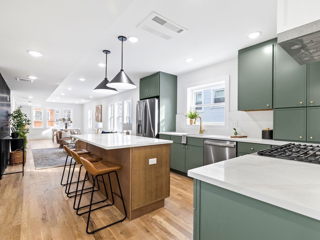 16 High Street, Unit 2 Somerville, MA 02144 - Photo 2 of 34 a kitchen with stainless steel appliances kitchen island granite countertop a sink and cabinets