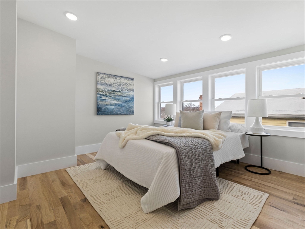 16 High Street, Unit 2 Somerville, MA 02144 - Photo 21 of 34 a spacious bedroom with a bed and wooden floor