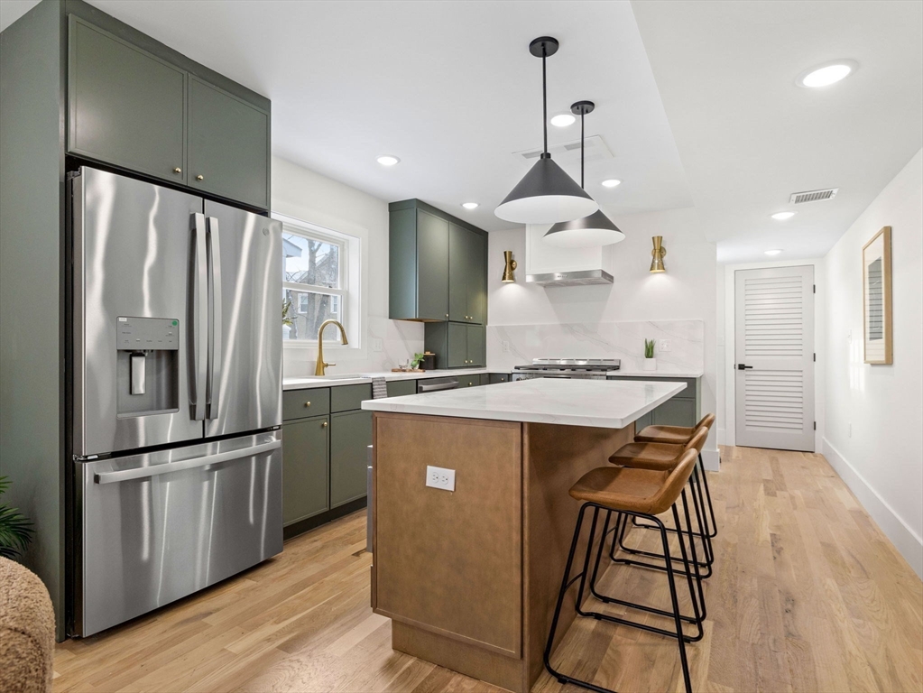 16 High Street, Unit 2 Somerville, MA 02144 - Photo 3 of 34 a kitchen with stainless steel appliances granite countertop a refrigerator a sink dishwasher a stove and a refrigerator with wooden floor