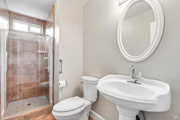 a bathroom with a sink a toilet and a mirror