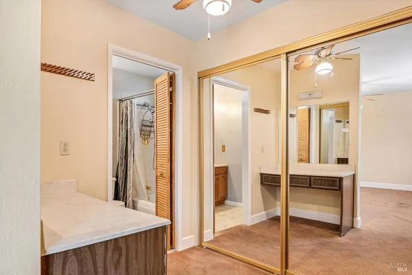 a view of a hallway with bathroom and wooden floor