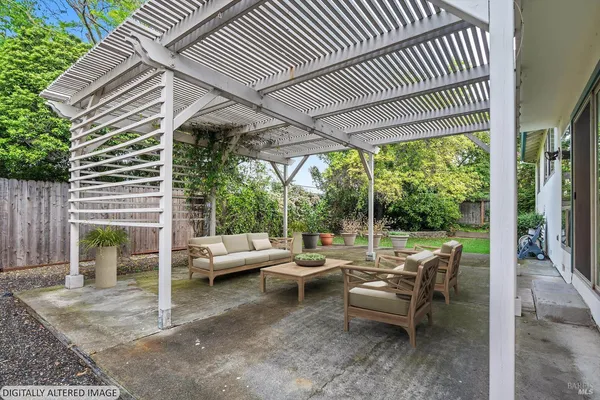 a view of a patio with table and chairs and couches with wooden floor and fence