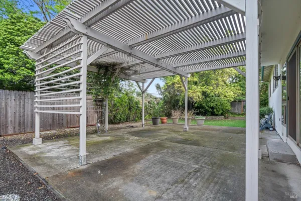 a view of a patio with a table chairs and wooden fence
