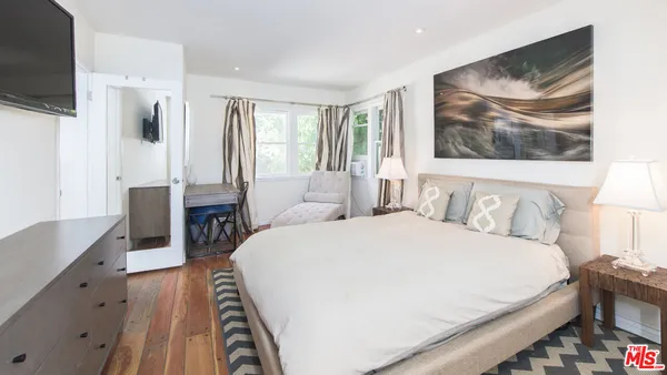 a bedroom with a bed and a flat screen tv