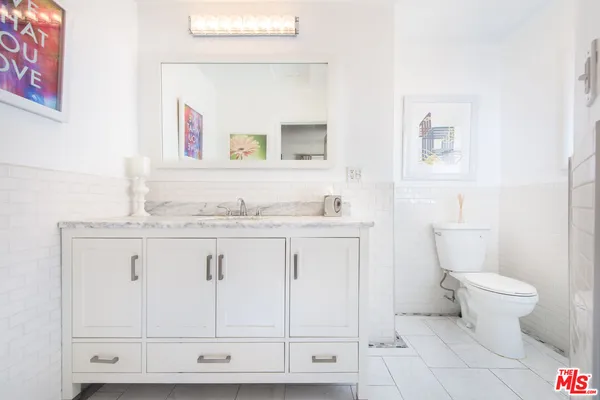 a bathroom with a granite countertop toilet sink and mirror