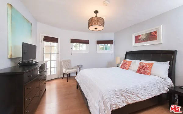 a bedroom with a bed and a flat screen tv