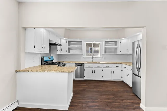 a kitchen with stainless steel appliances granite countertop a stove a sink and a refrigerator