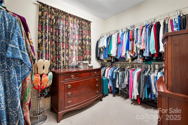 a view of walk in closet with clothes and shoes