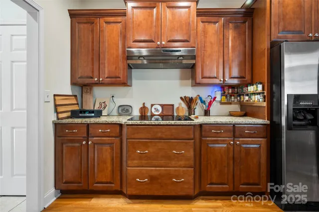 a kitchen with stainless steel appliances granite countertop a refrigerator and a stove top oven
