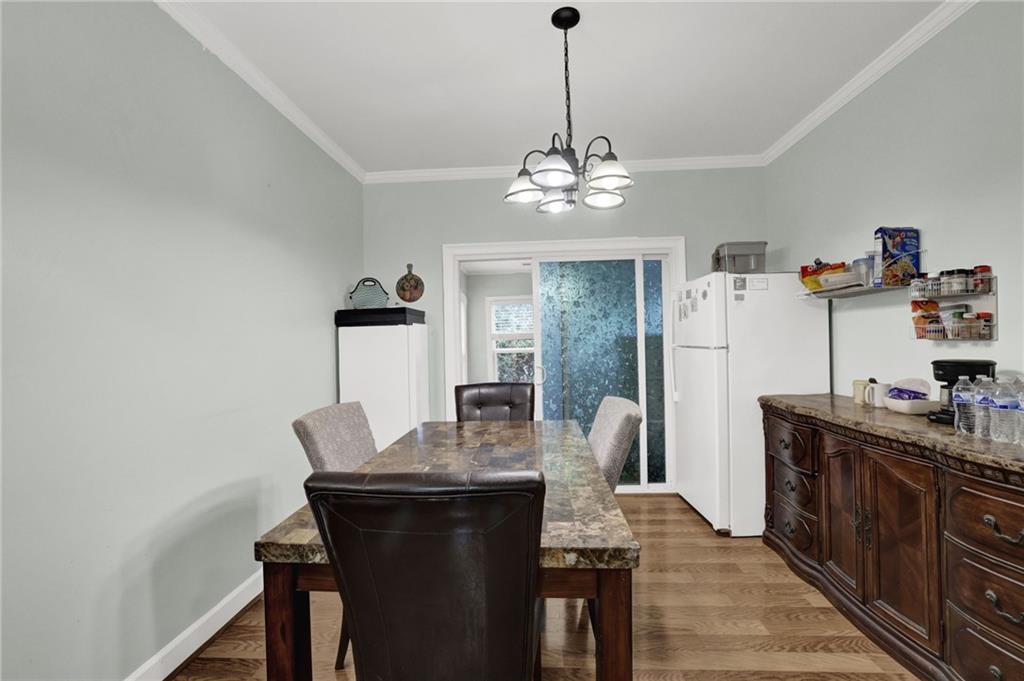 3825 Lavista Road, Unit O1 Tucker, GA 30084 - Photo 12 of 36 a view of a dining room with furniture a chandelier and wooden floor