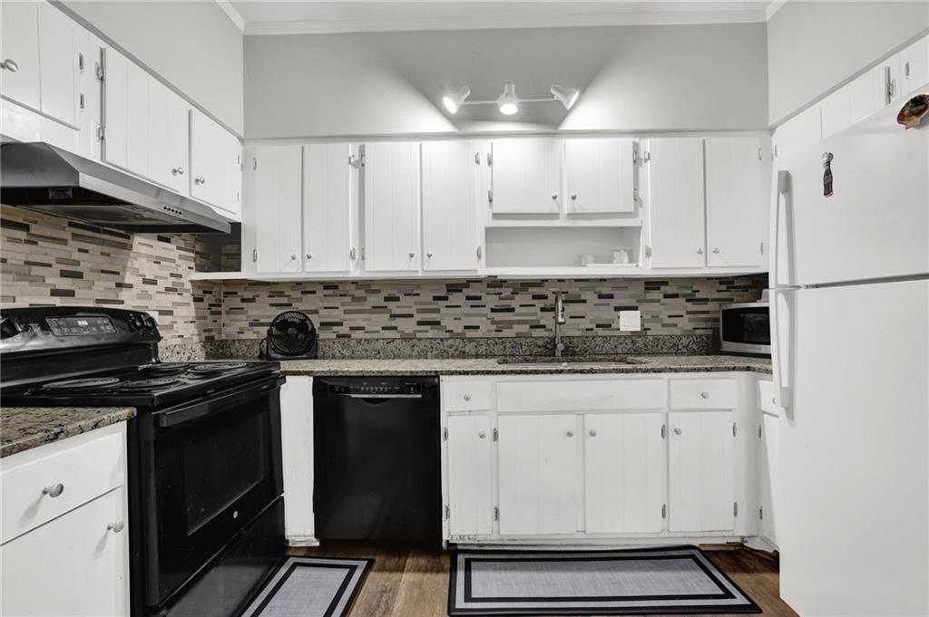 3825 Lavista Road, Unit O1 Tucker, GA 30084 - Photo 16 of 36 a kitchen with granite countertop white cabinets and black appliances