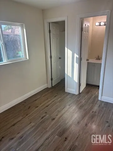 an empty room with wooden floor and a window