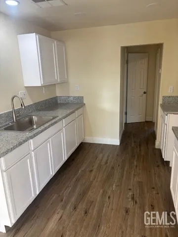a kitchen with granite countertop a sink and a stove top oven
