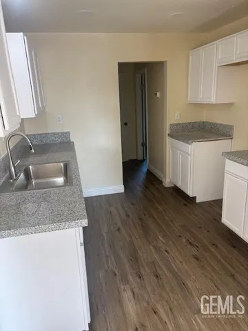 a kitchen with granite countertop a sink and a stove top oven