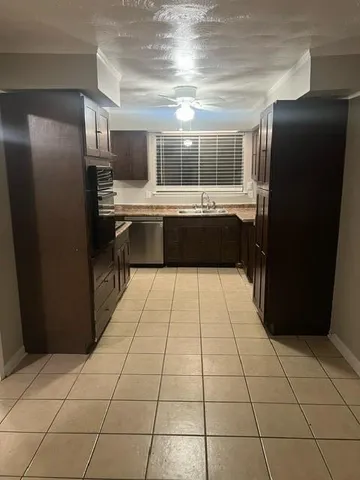 a kitchen with a black refrigerator and a stove