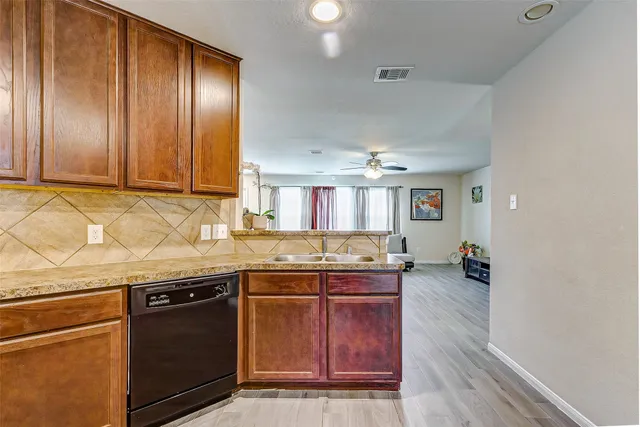 a kitchen with granite countertop stainless steel appliances and wooden cabinets