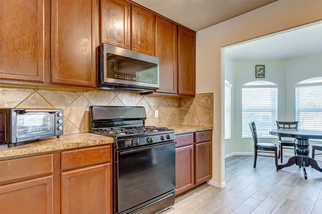 a kitchen with wooden cabinets and a stove top oven