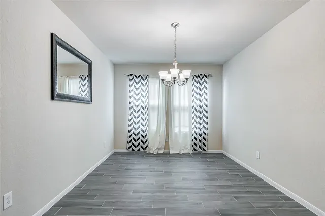 an empty room with wooden floor and chandeliers