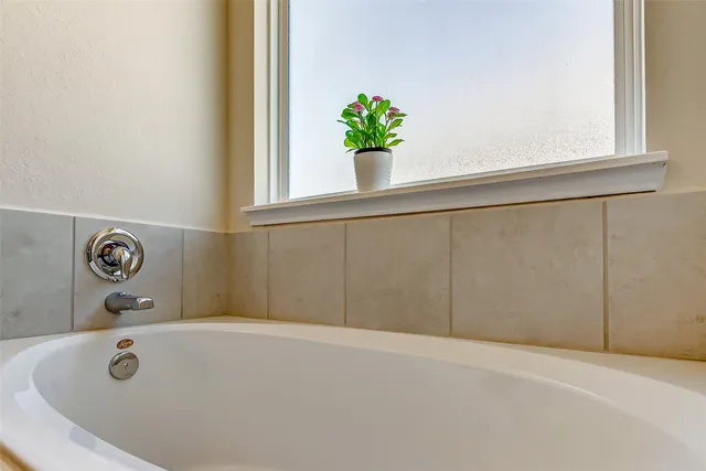 a bathroom with a tub and window