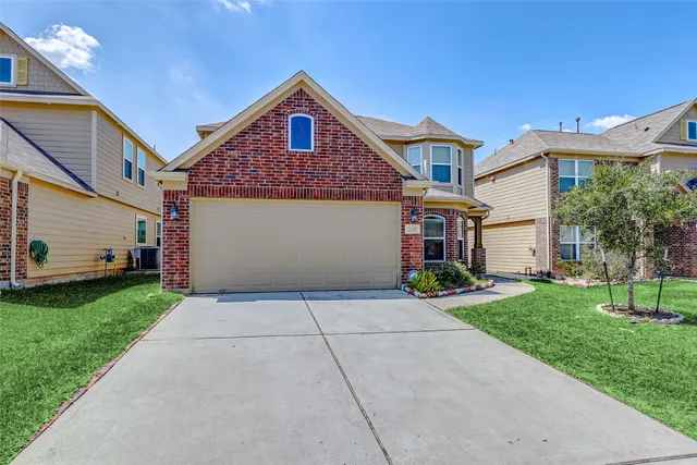 a front view of a house with a yard and garage