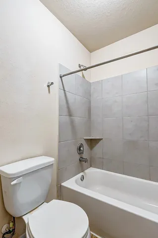 a white toilet and tub sitting next to a bathroom sink