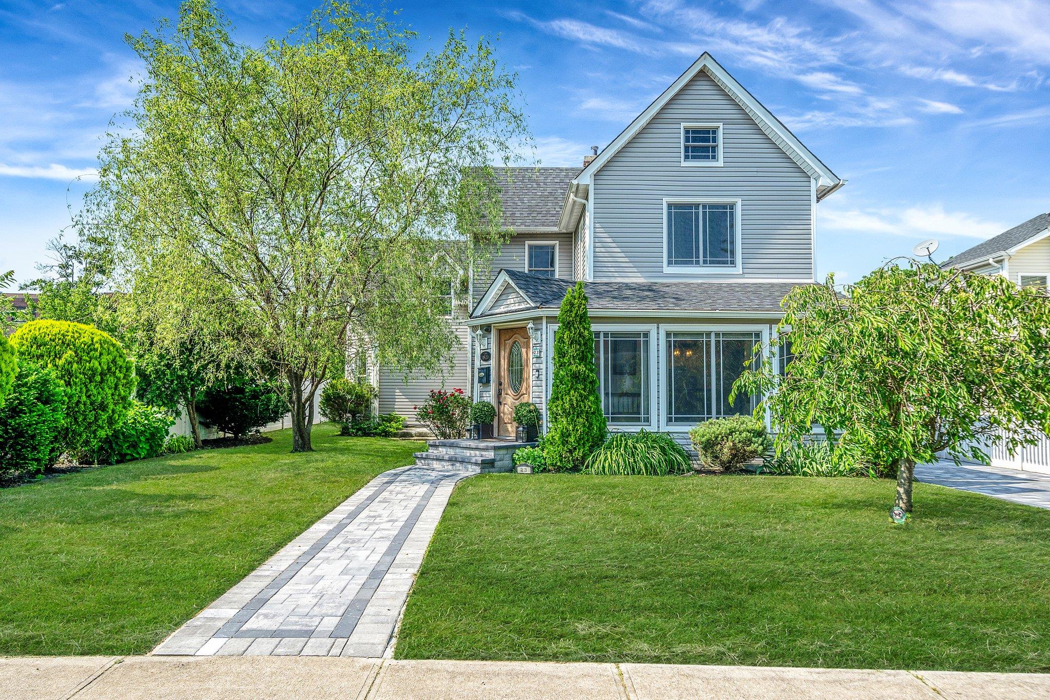 Traditional-style home featuring a front yard and roof with shingles