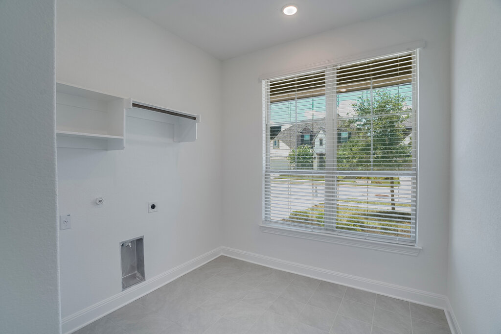 2920 Hadley Way Leander, TX 78641 - Photo 18 of 20 A well-lit utility space provides functional laundry hookups and convenient storage shelving.