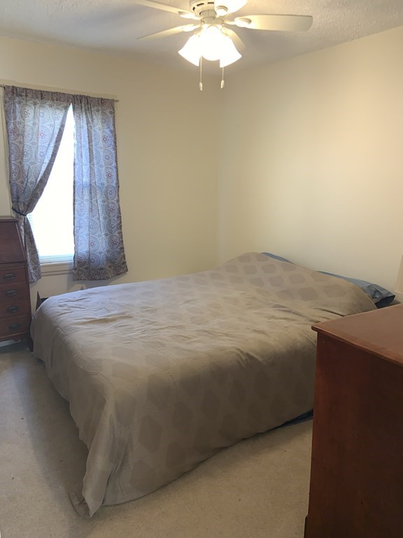35 Barber Street Springfield, MA 01109 - Photo 8 of 13 a bedroom with a bed and a chandelier