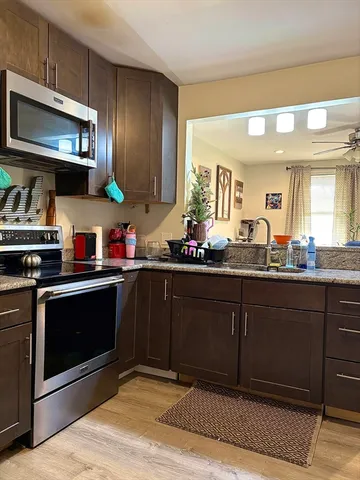 a kitchen with stainless steel appliances granite countertop a stove a sink and a microwave