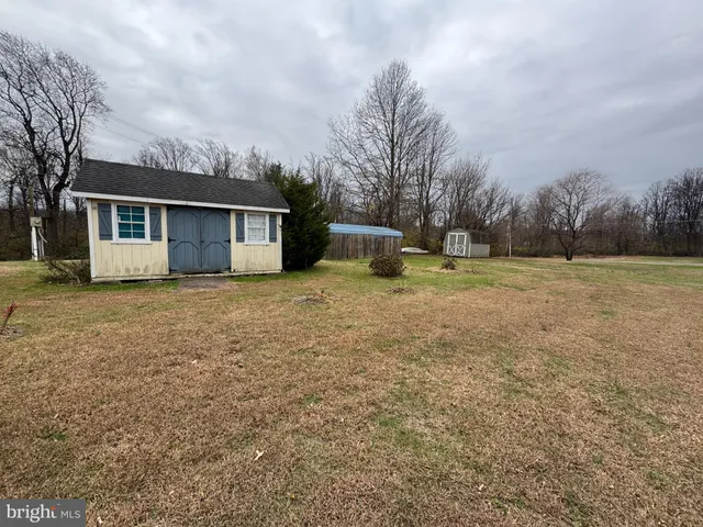 a view of a house with backyard and trees