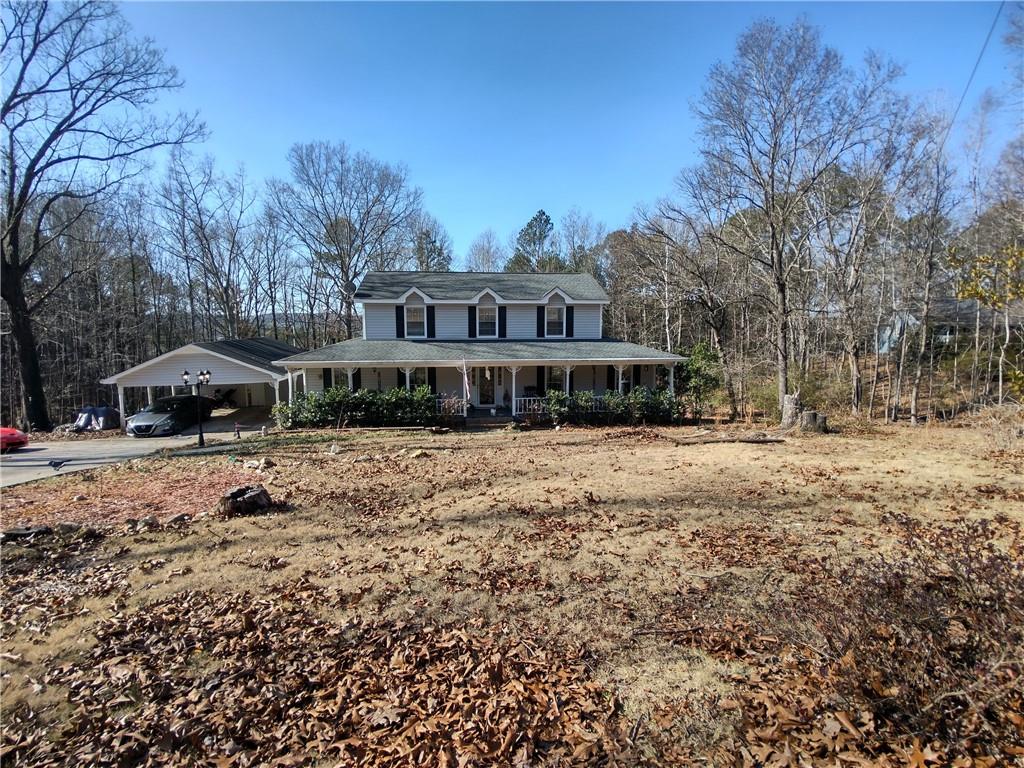 a front view of a house with a yard covered with snow and trees